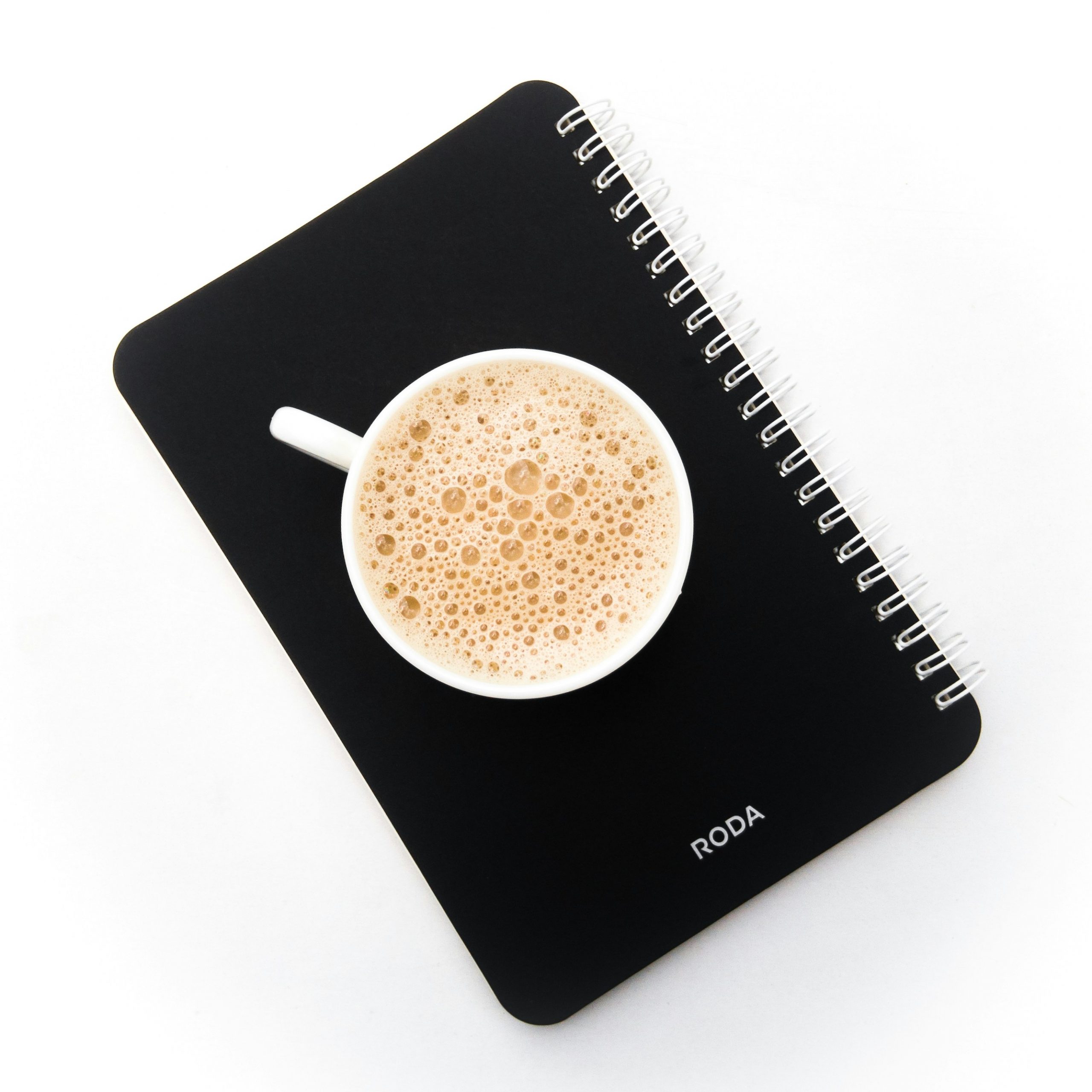 Close up of a notebook with handwritten plan for a website structure next to a cup of coffee