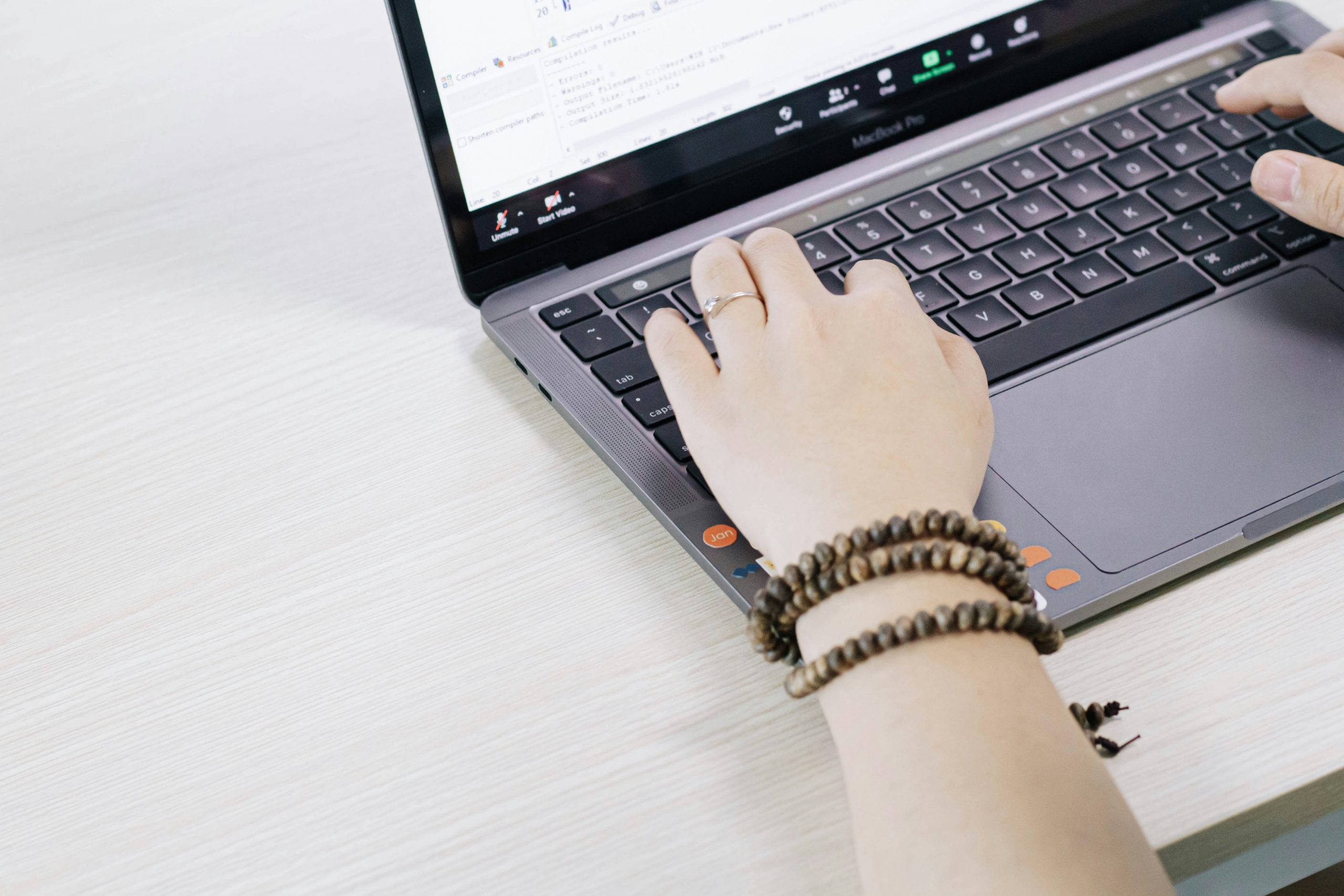 Writer typing on a laptop with SEO tools open on a second monitor