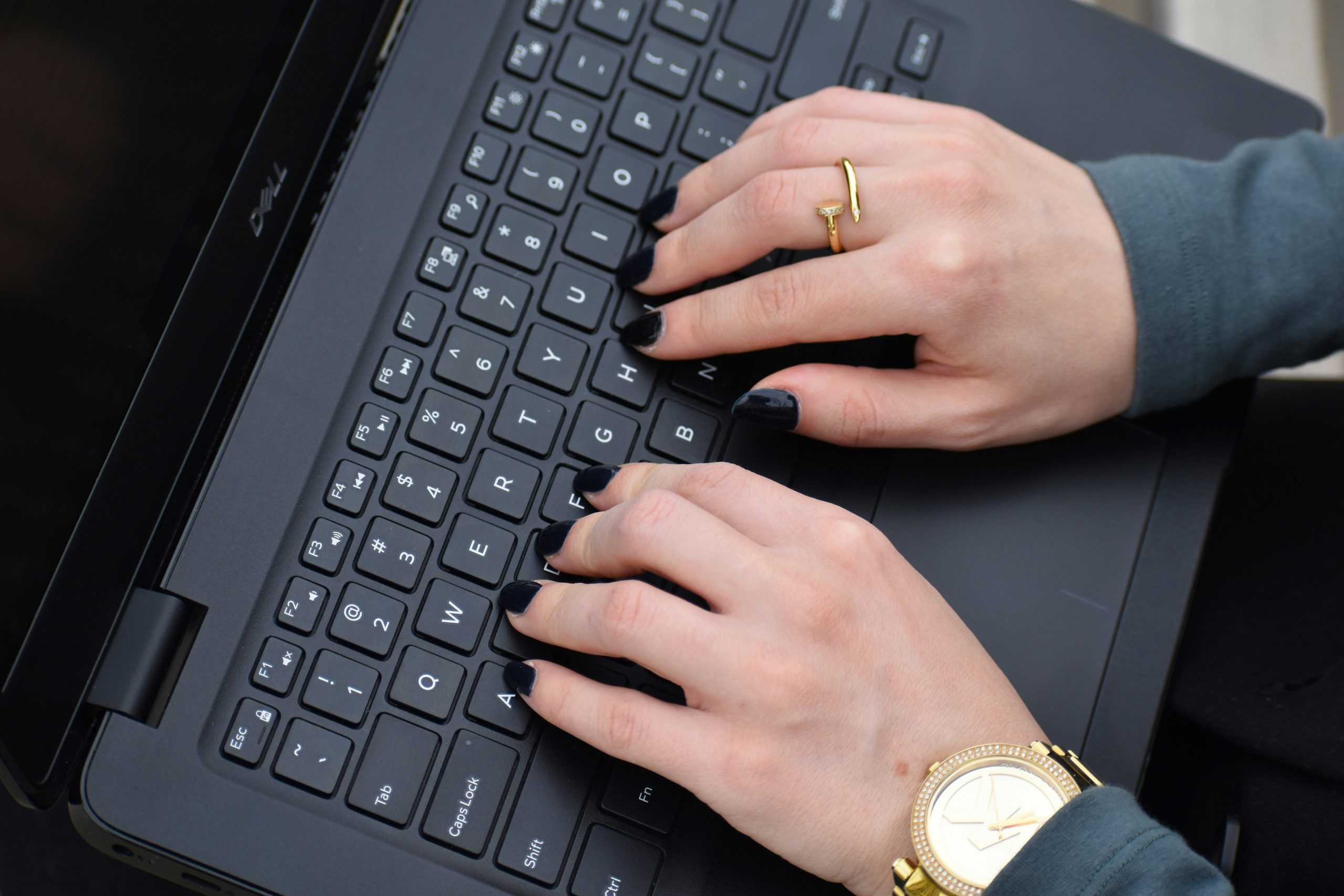 Close-up of hands typing on a laptop with code and Elementor design visible on screen