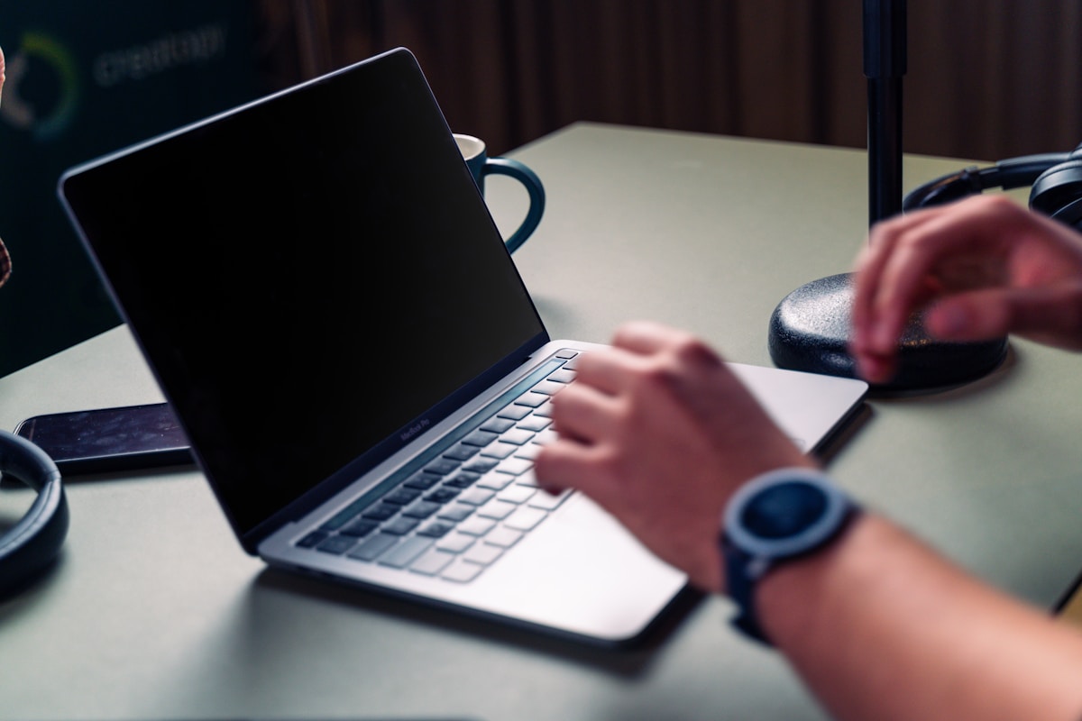 Ordinateur portable, tasse de café, mains tapant sur le clavier.