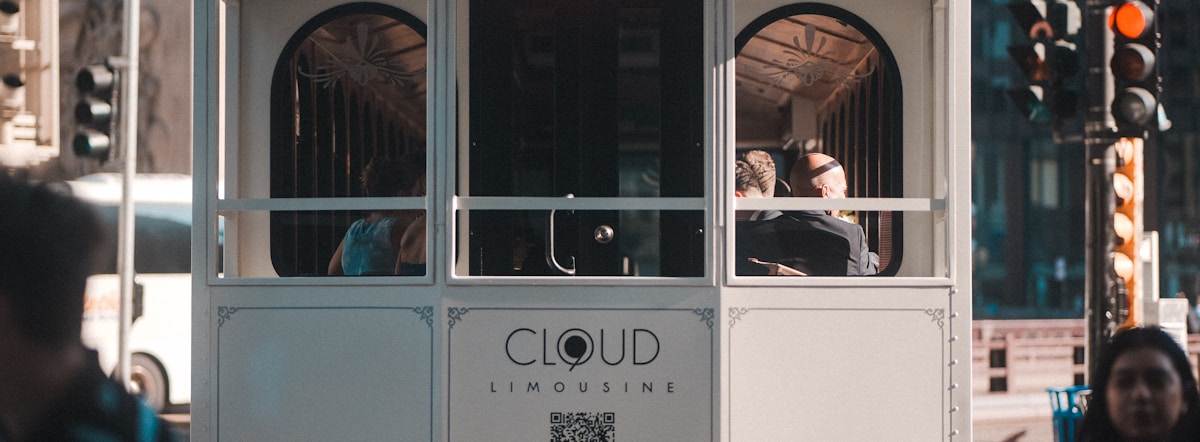 People ride on a trolley car in the city.