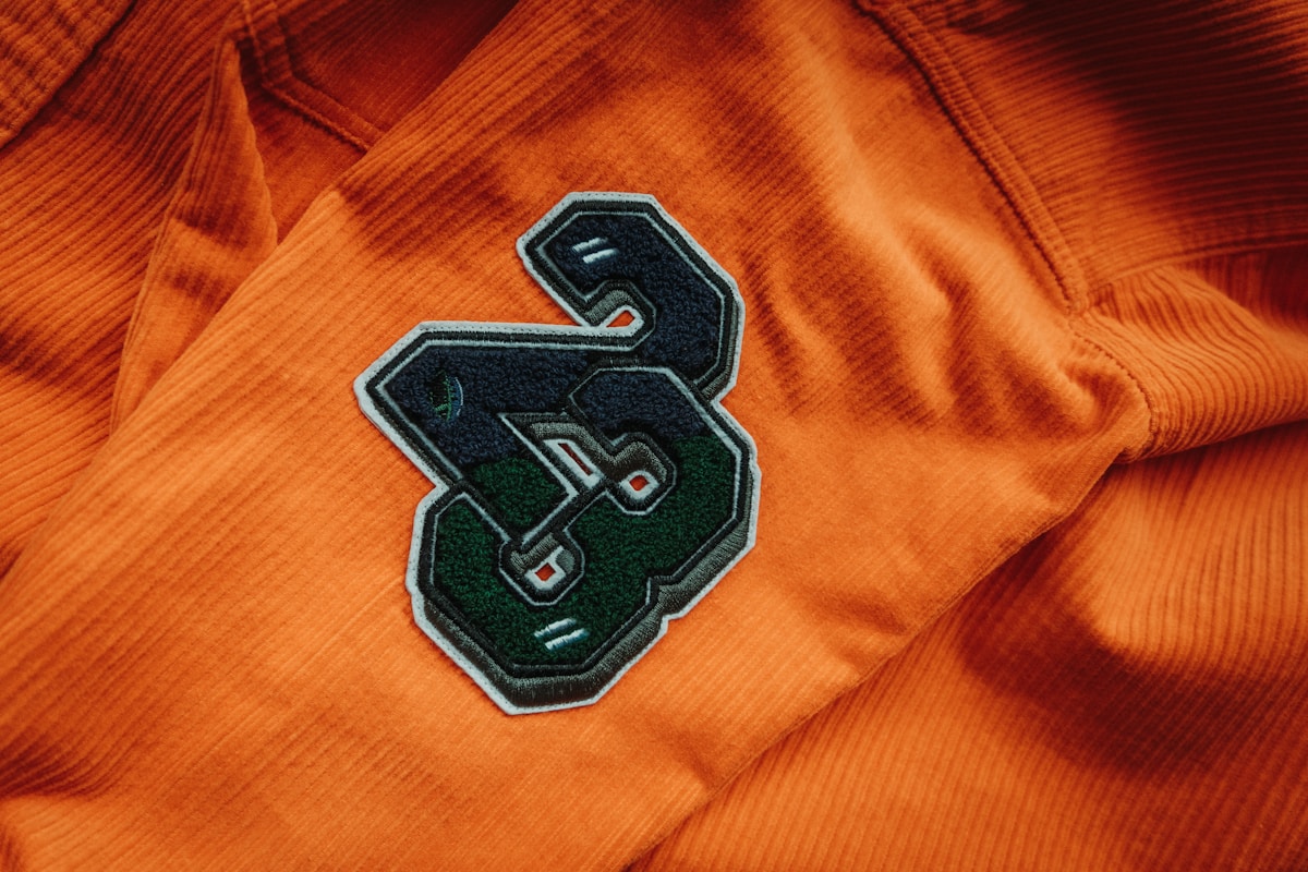 Un gros plan d'un t-shirt orange avec la lettre s.